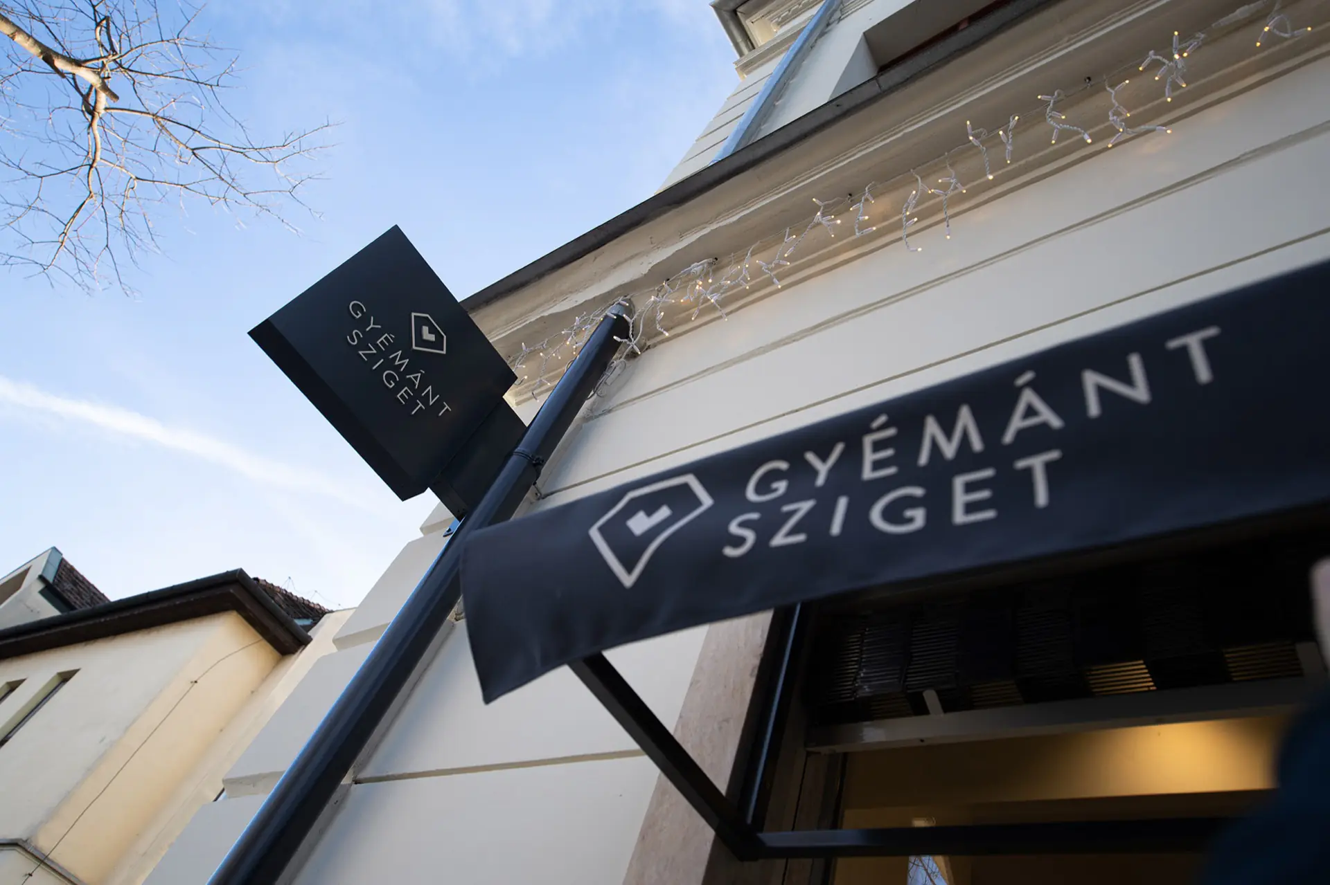 A Gyémánt Sziget üzlet cégére és bejárat fölötti vászna a megtervezett logóval